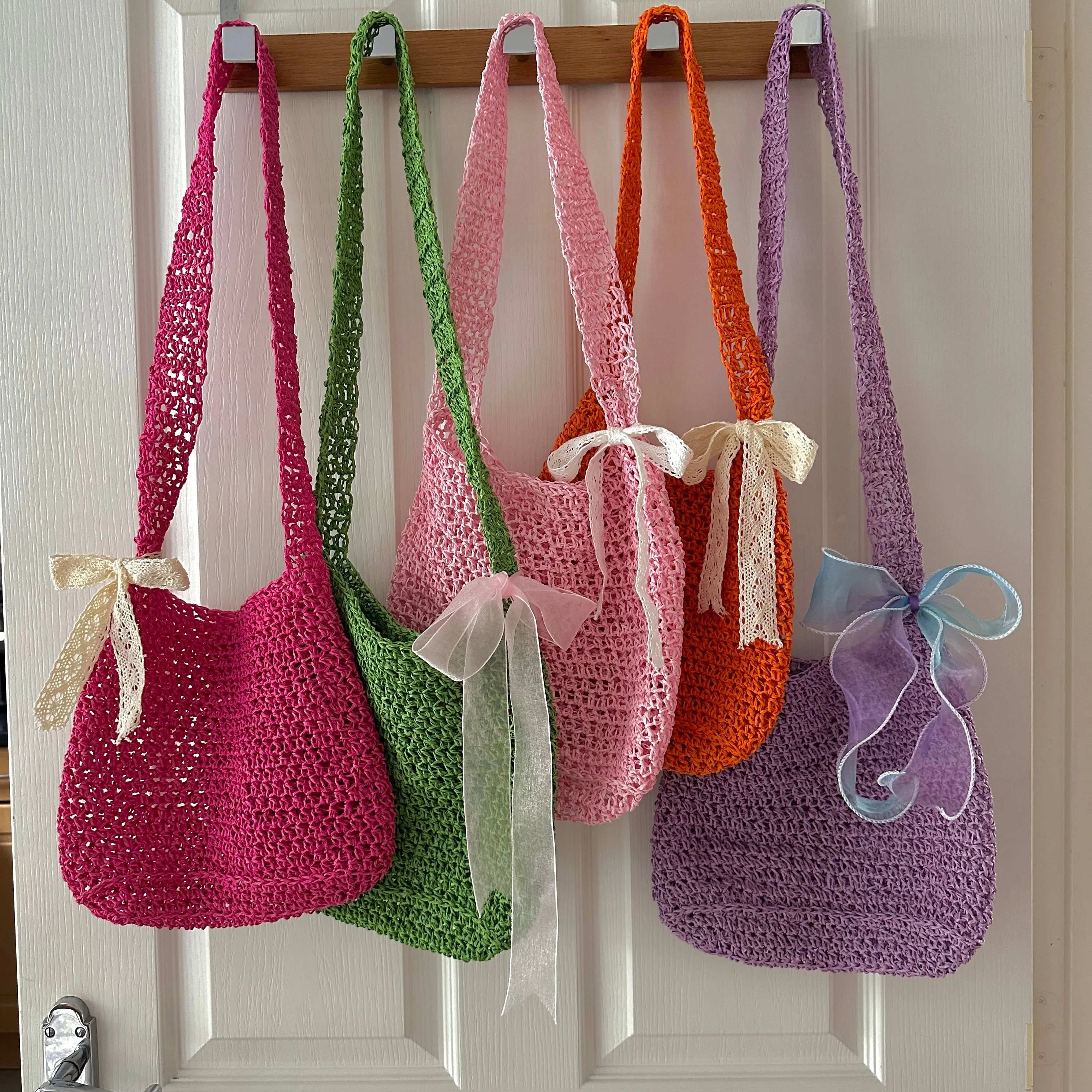 Handmade orange crochet straw bag with cream lace bow