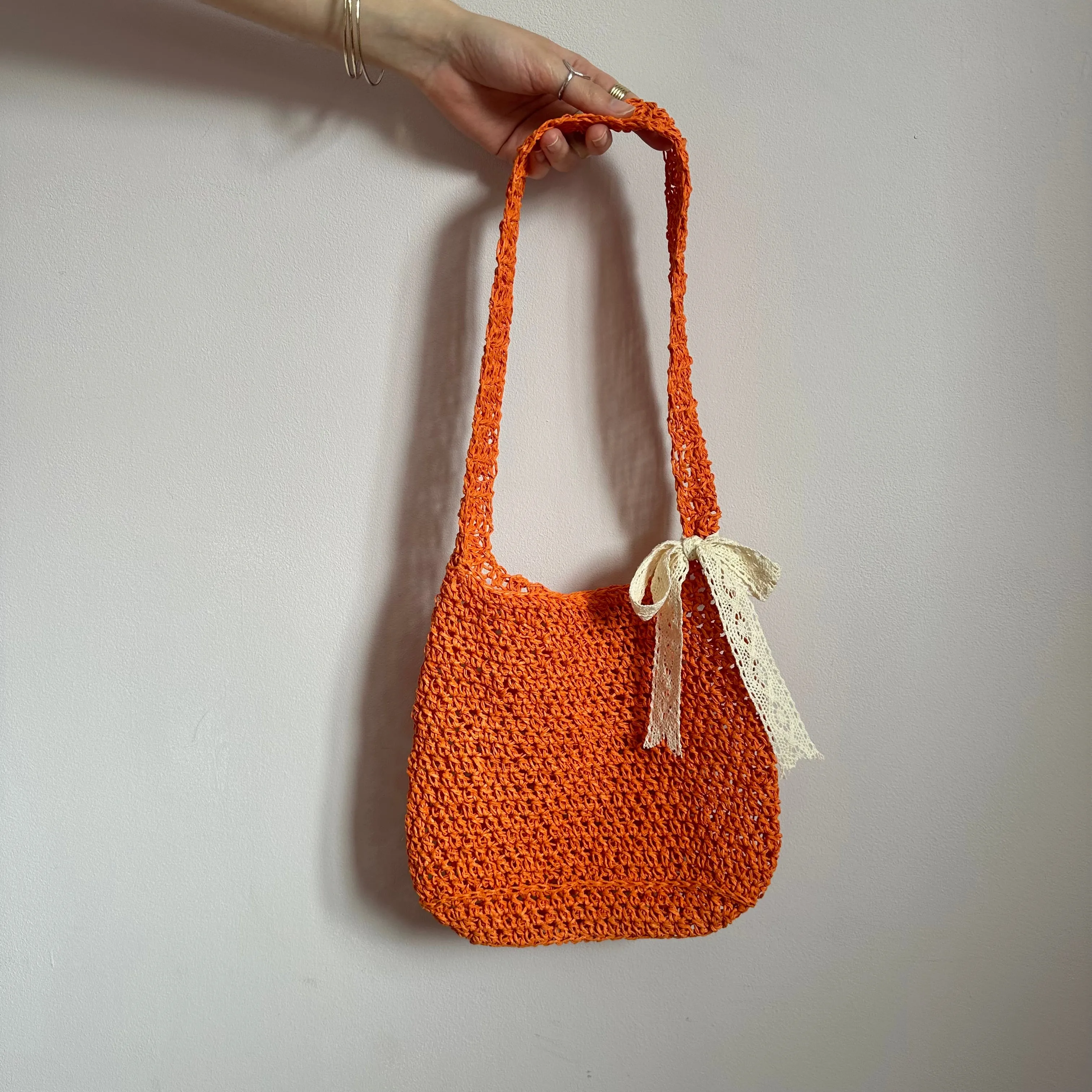 Handmade orange crochet straw bag with cream lace bow